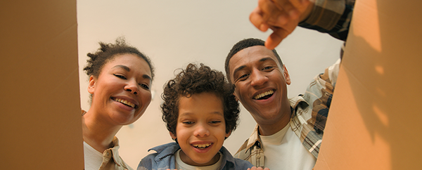 Young family looking inside a box