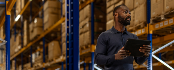 man standing in warehouse with tablet in hand